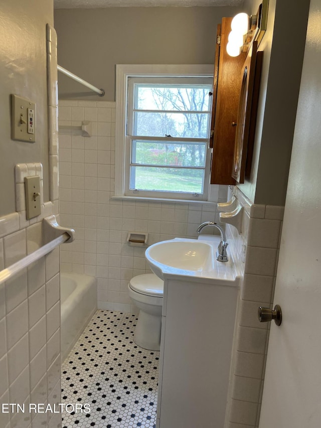 full bath featuring tile patterned flooring, vanity, tile walls, toilet, and  shower combination