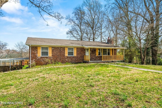 ranch-style home featuring covered porch, a chimney, a front lawn, and brick siding