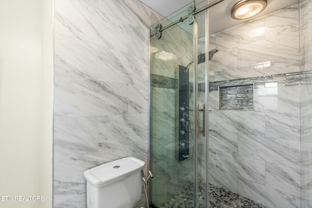 bathroom with toilet and a shower stall