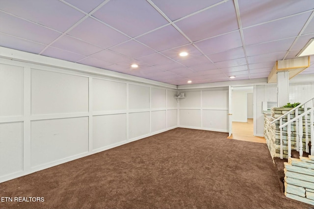 finished below grade area featuring recessed lighting, carpet floors, a decorative wall, and a paneled ceiling
