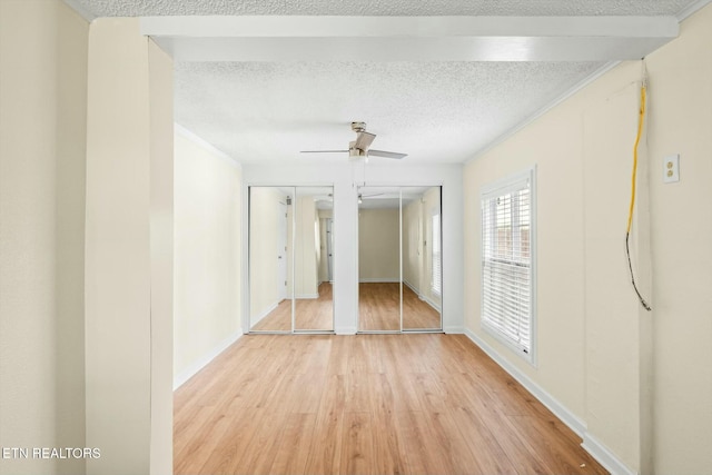 spare room with a textured ceiling, crown molding, ceiling fan, and light wood-type flooring