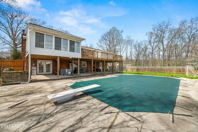 view of pool featuring a patio area, french doors, a deck, a fenced backyard, and central AC unit