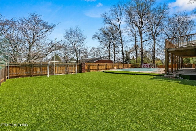 view of yard with a fenced backyard, a wooden deck, and an outdoor structure