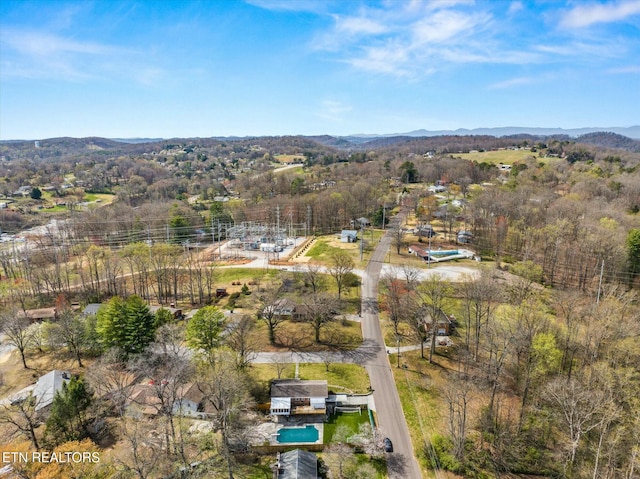 aerial view featuring a wooded view and a mountain view