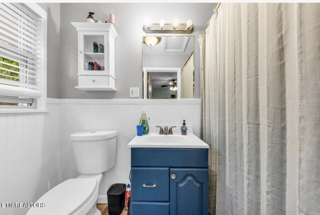 bathroom featuring toilet, vanity, and a ceiling fan