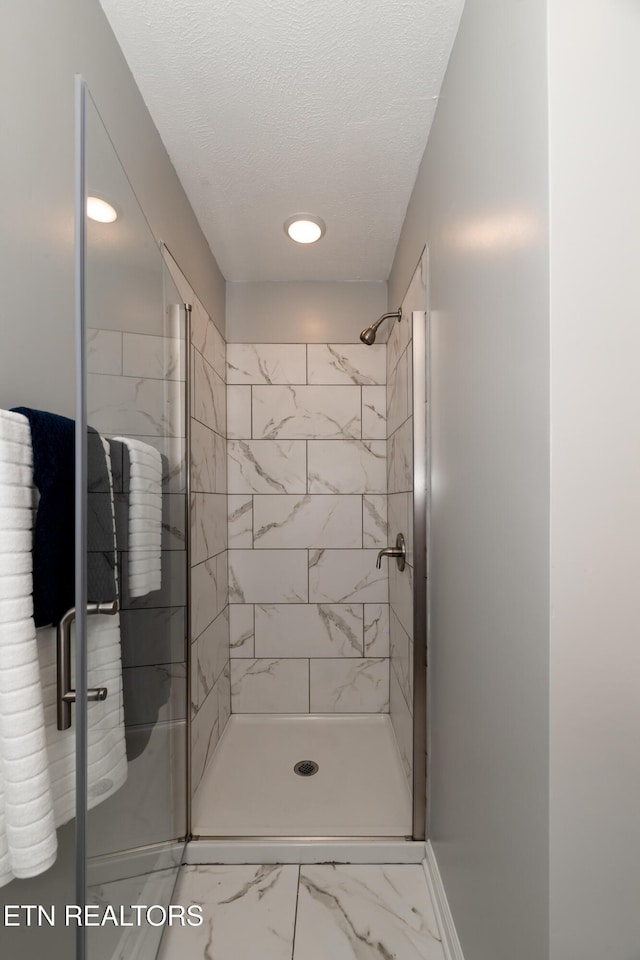 733 Waco Rd, Knoxville, TN 37919 - full bath with baseboards, marble finish floor, a textured ceiling, and a shower stall