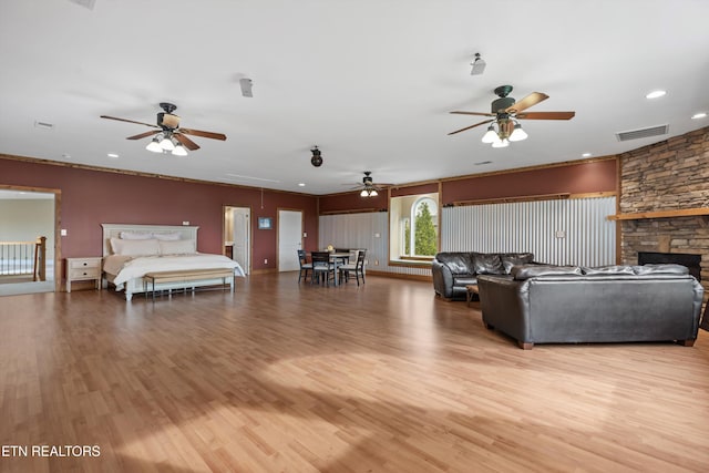 134 At Crumley Rd, Rockford, TN 37853 - living room featuring attic access, light wood finished floors, ceiling fan, visible vents, and a stone fireplace