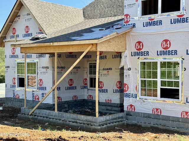 property entrance featuring roof with shingles