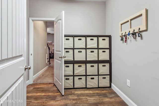hallway featuring baseboards and dark wood-type flooring