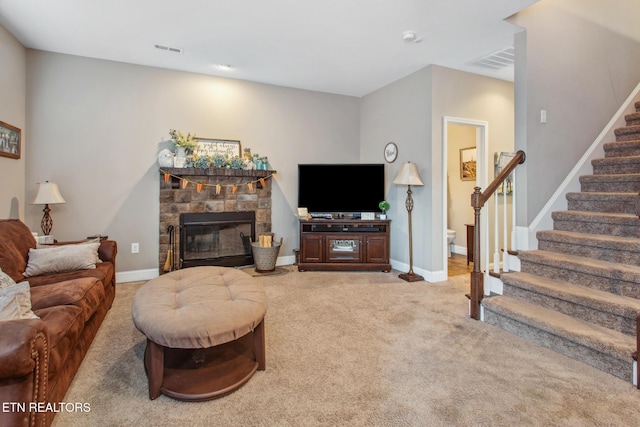 living room featuring stairs, carpet flooring, baseboards, visible vents, and a fireplace