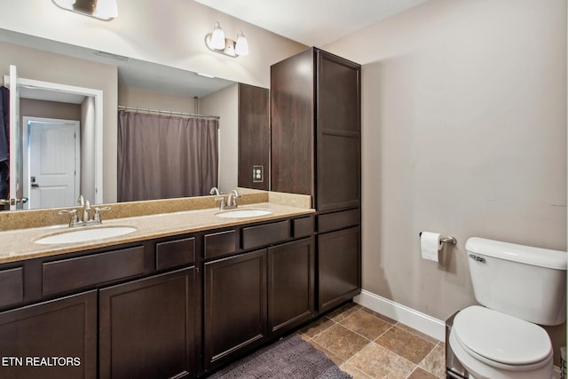 full bath featuring toilet, a sink, baseboards, and visible vents