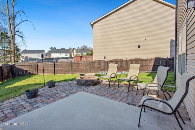 view of patio with a fenced backyard, a fire pit, and a residential view