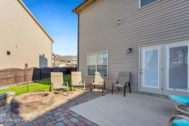 view of patio featuring an outdoor fire pit and fence