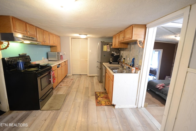 519 Temple Rd, Seymour, TN 37865 - kitchen with light countertops, stainless steel appliances, under cabinet range hood, a sink, and light wood-style floors