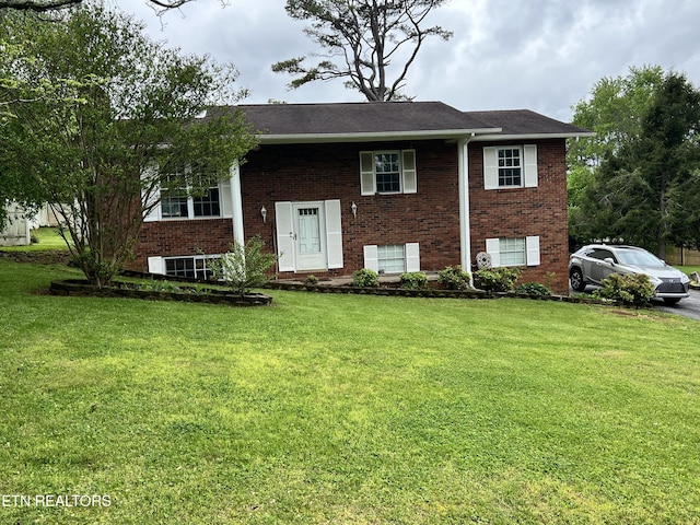 split foyer home featuring brick siding and a front yard