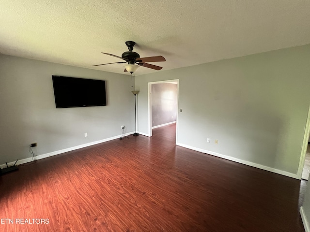 empty room featuring baseboards, a ceiling fan, wood finished floors, and a textured ceiling
