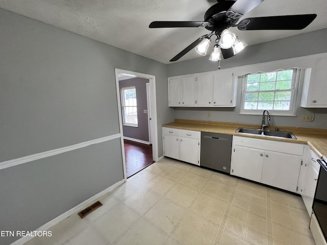 kitchen featuring a sink, plenty of natural light, visible vents, light floors, and dishwasher