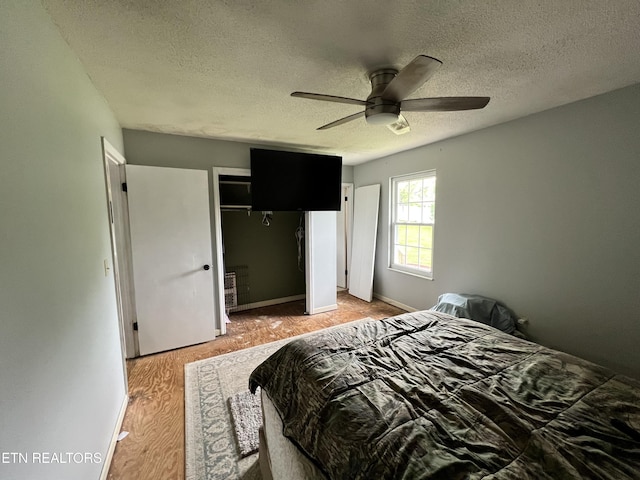 bedroom featuring a closet, a ceiling fan, a textured ceiling, and light wood-type flooring
