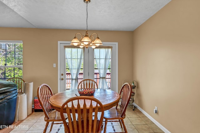 dining area featuring plenty of natural light, a notable chandelier, and a textured ceiling
