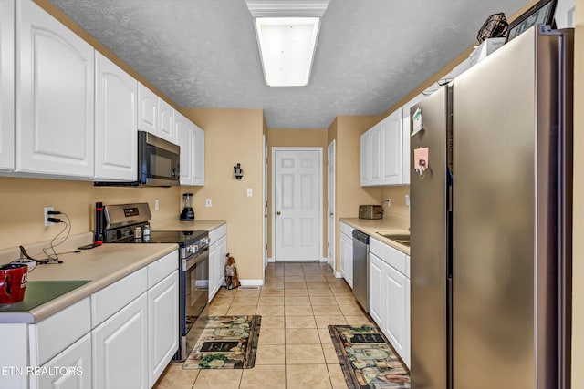 kitchen with light tile patterned floors, white cabinets, baseboards, light countertops, and stainless steel appliances