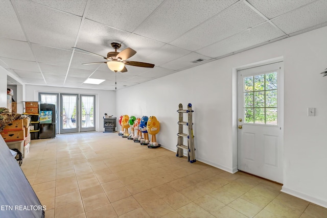 playroom featuring a ceiling fan, a paneled ceiling, and plenty of natural light