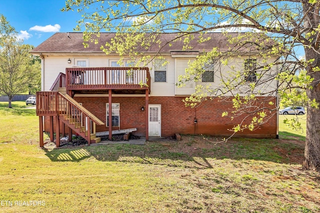 back of property with a lawn, brick siding, a shingled roof, stairs, and a deck