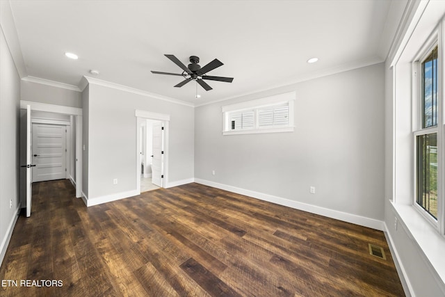 unfurnished bedroom featuring dark wood-style flooring, baseboards, ornamental molding, and visible vents