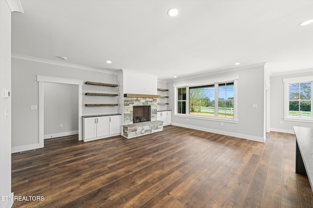 unfurnished living room with ornamental molding, baseboards, a fireplace, and dark wood-style floors