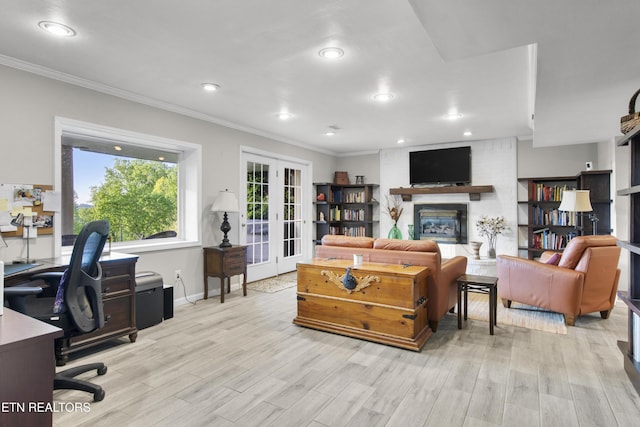 living room with a fireplace, french doors, crown molding, and light wood-style flooring