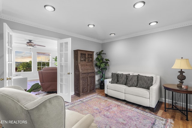 living area featuring crown molding, ceiling fan, french doors, baseboards, and wood finished floors