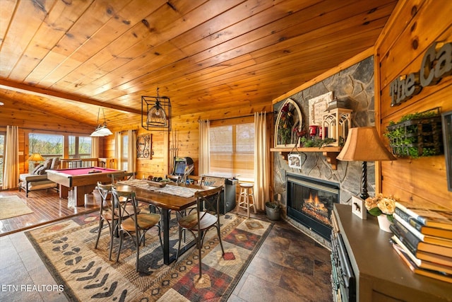dining room with pool table, a fireplace, wooden walls, and lofted ceiling