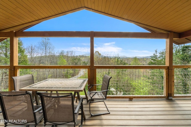 wooden deck featuring outdoor dining area and a mountain view