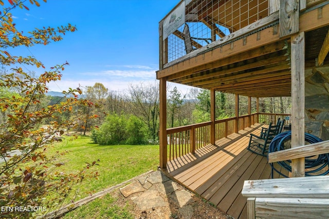 wooden terrace featuring a lawn