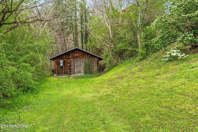 view of yard featuring a view of trees and an outdoor structure