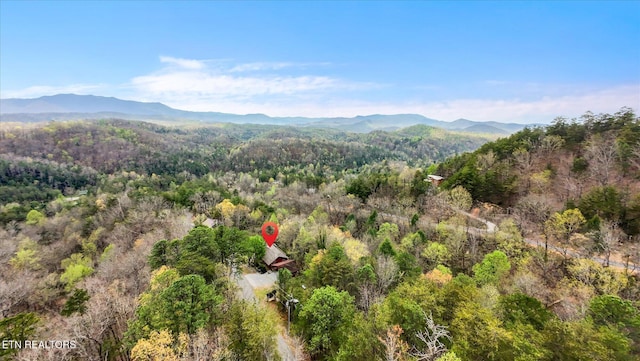 birds eye view of property featuring a wooded view and a mountain view