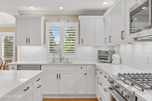 1647 Banebury Ln, Alcoa, TN 37701 - kitchen with stainless steel appliances, healthy amount of natural light, white cabinetry, ornamental molding, and light stone counters