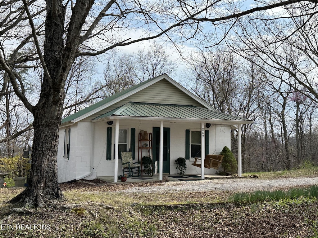 889 River Rd, Jacksboro, TN 37757 - view of front of property featuring metal roof, a porch, and concrete block siding