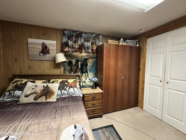 bedroom with a closet, a textured ceiling, and wooden walls