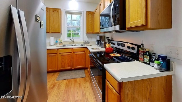 122 Lake View Dr, Knoxville, TN 37920 - kitchen with light countertops, stainless steel appliances, a sink, light wood-style floors, and brown cabinetry