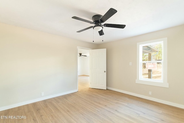 spare room with light wood finished floors, baseboards, and ceiling fan