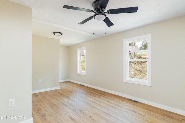 empty room with baseboards, light wood-style floors, ceiling fan, and visible vents