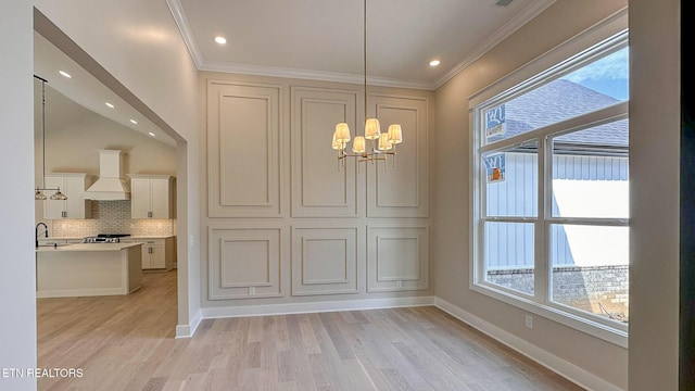 409 Goweli Trl, Vonore, TN 37885 - unfurnished dining area featuring a chandelier, light wood-type flooring, ornamental molding, baseboards, and a sink