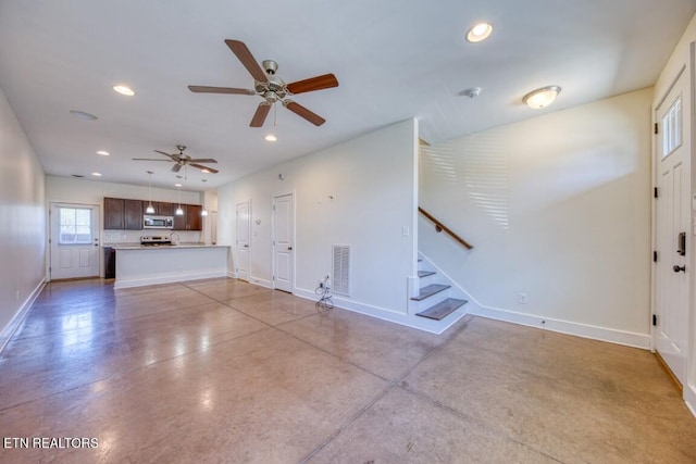 unfurnished living room featuring finished concrete flooring, baseboards, and recessed lighting