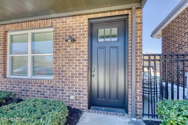 view of exterior entry with brick siding