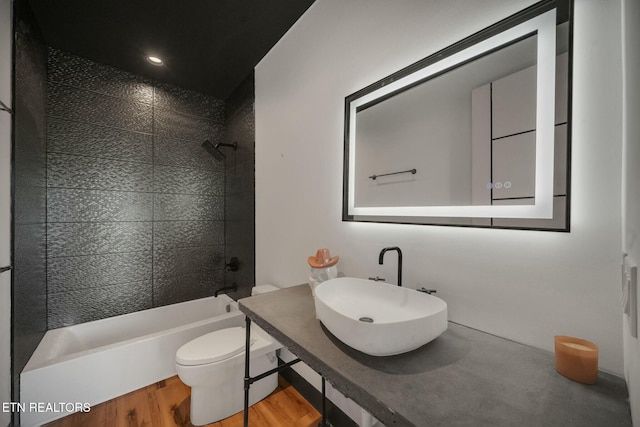210 Granite Dr, Sevierville, TN 37876 - bathroom featuring wood finished floors, toilet, tiled shower / bath combo, and a sink