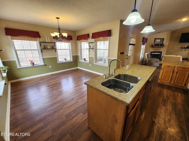 kitchen featuring a sink, a chandelier, a center island with sink, dark wood-style floors, and open floor plan