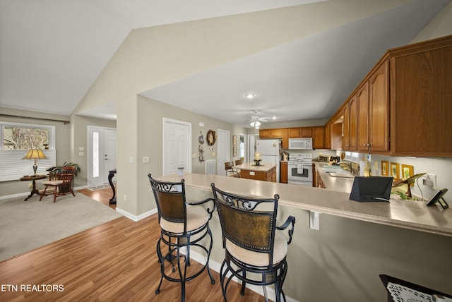 118 Windsor Rd, Crossville, TN 38558 - kitchen featuring white appliances, a sink, light wood-style floors, ceiling fan, and a peninsula