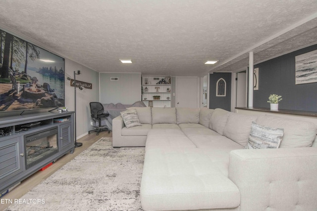 living area with visible vents, wood finished floors, and a textured ceiling
