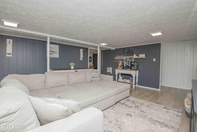 living room with a textured ceiling and wood finished floors