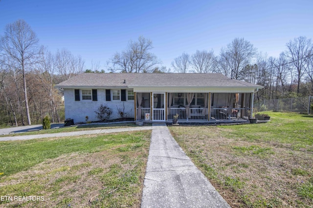view of front of property featuring a front lawn, a sunroom, fence, and roof with shingles